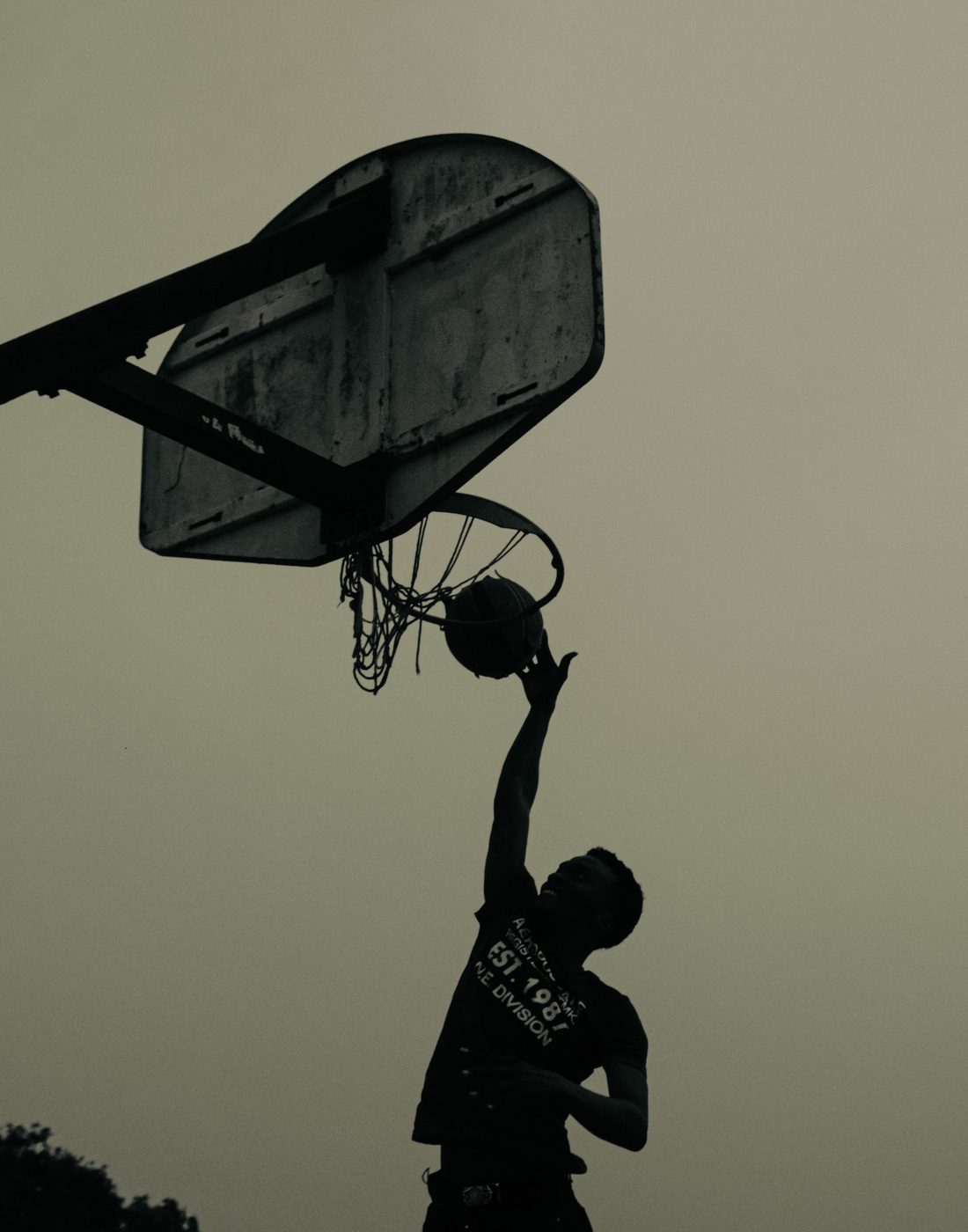 Basketball player rising for a dunk, silhouetted